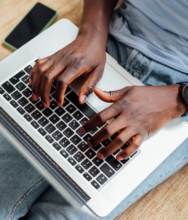 A man typing on a laptop computer