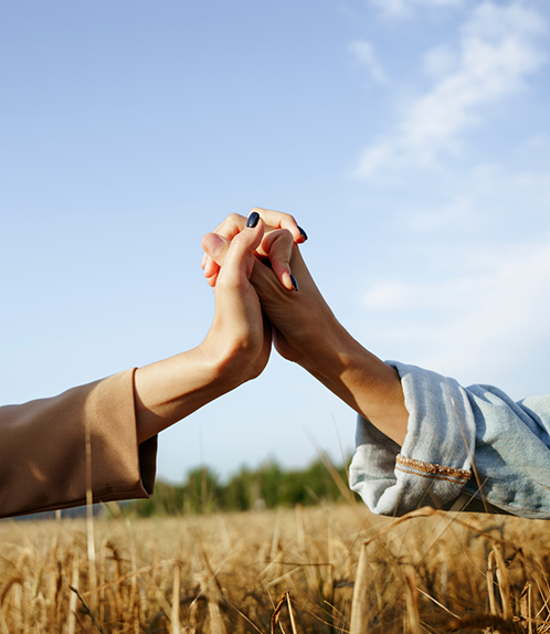 Two people outside holding hands