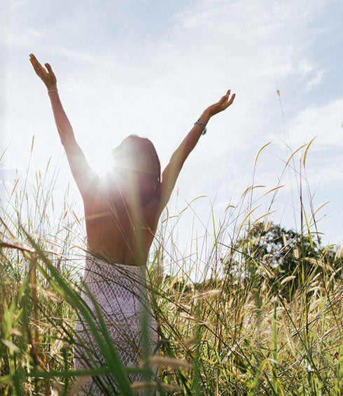 A woman holding her hands open towards the sky