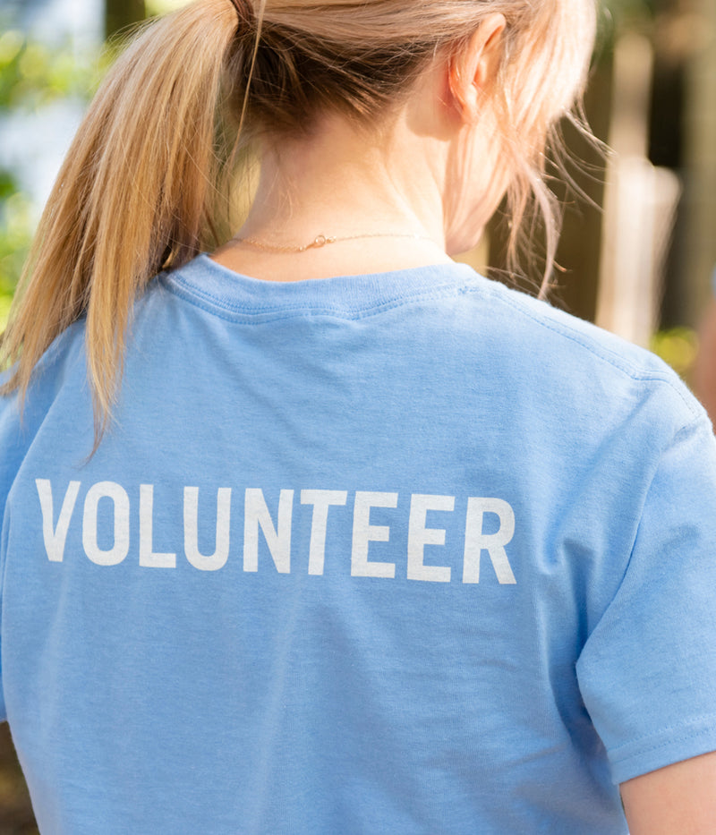 A person wearing a shirt that says "Volunteer"