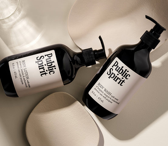 Public Spirit Body Wash and Body Lotion Laying on Ground in Studio Setting